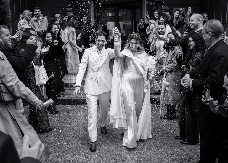 Les mariés sortent de la mairie de Paris sous une pluie de confettis.